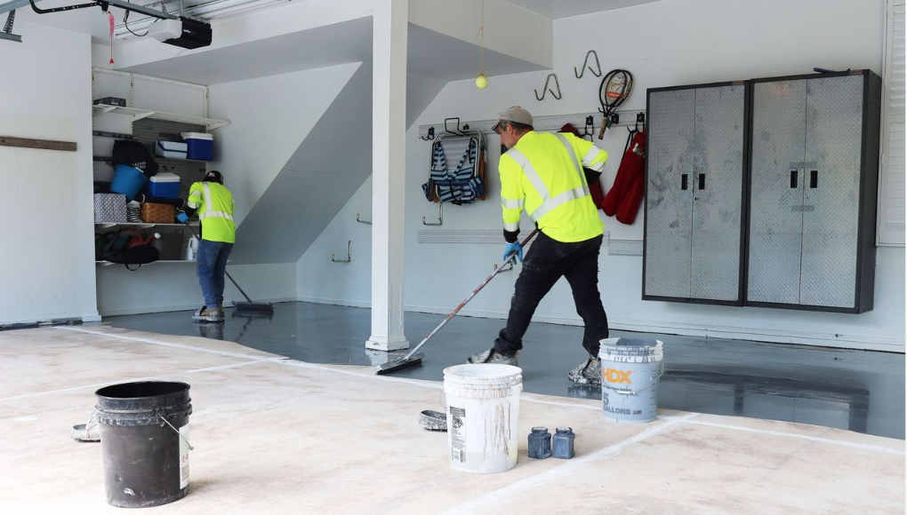 Industrious Garage technicians installing basecoat of polyaspartic floor coating in a 2 car garage